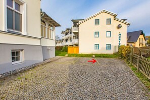 Ein Gebäude mit einem Schild, auf dem 'MOTEL' steht, und eine Kopfsteinpflaster-Auffahrt mit einem roten Pfeil, der nach rechts zeigt.