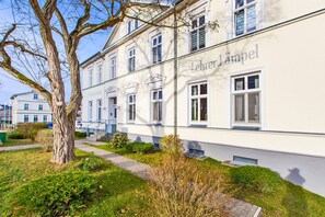 Ein Gebäude mit der Aufschrift 'Lehrer Lampel' an der Fassade, das einen traditionellen Baustil mit zahlreichen Fenstern und einem gut sichtbaren Eingang aufweist.