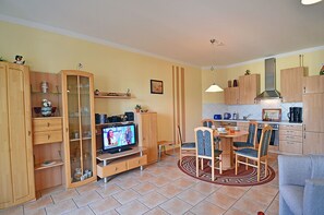 Un espai habitable compacte amb menjador, cuina i zona d'entreteniment.