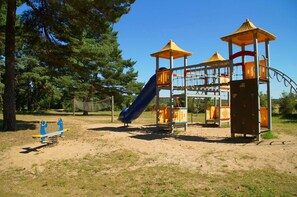 A playground with a slide, climbing structures, and a seesaw. - Just 250 meters from the sandy Baltic Sea beach, balcony with patio furniture and a beach umbrella (Glowe)