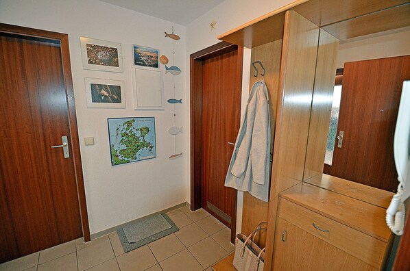 Quarto com portas de madeira, um mapa na parede, uma toalha pendurada e um espelho.