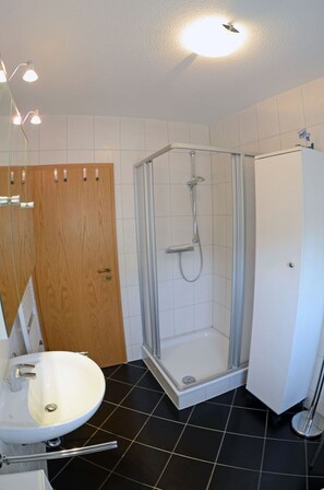 Ein Badezimmer mit Dusche, Waschbecken und Toilette.
