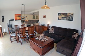 Ein Wohnzimmer mit einer Couch, einem Holztisch und einem Essbereich mit Stühlen und einem Tisch.