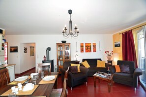 A living room with a sofa, a dining table set for two, a bookshelf, and a fireplace. - Apartment in a central location in Juliusruh, 25 m from the sandy beach with a view of the sea (Juliusruh)