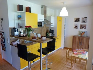 A compact kitchen with a microwave, coffee maker, and a dining area with two chairs. - Right on the beach, upscale amenities, 25 meters to the sandy beach, Wi-Fi (Juliusruh)