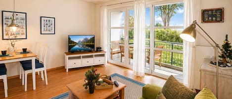Un salon équipé d’une télévision, d’un coin repas et d’un balcon avec vue.