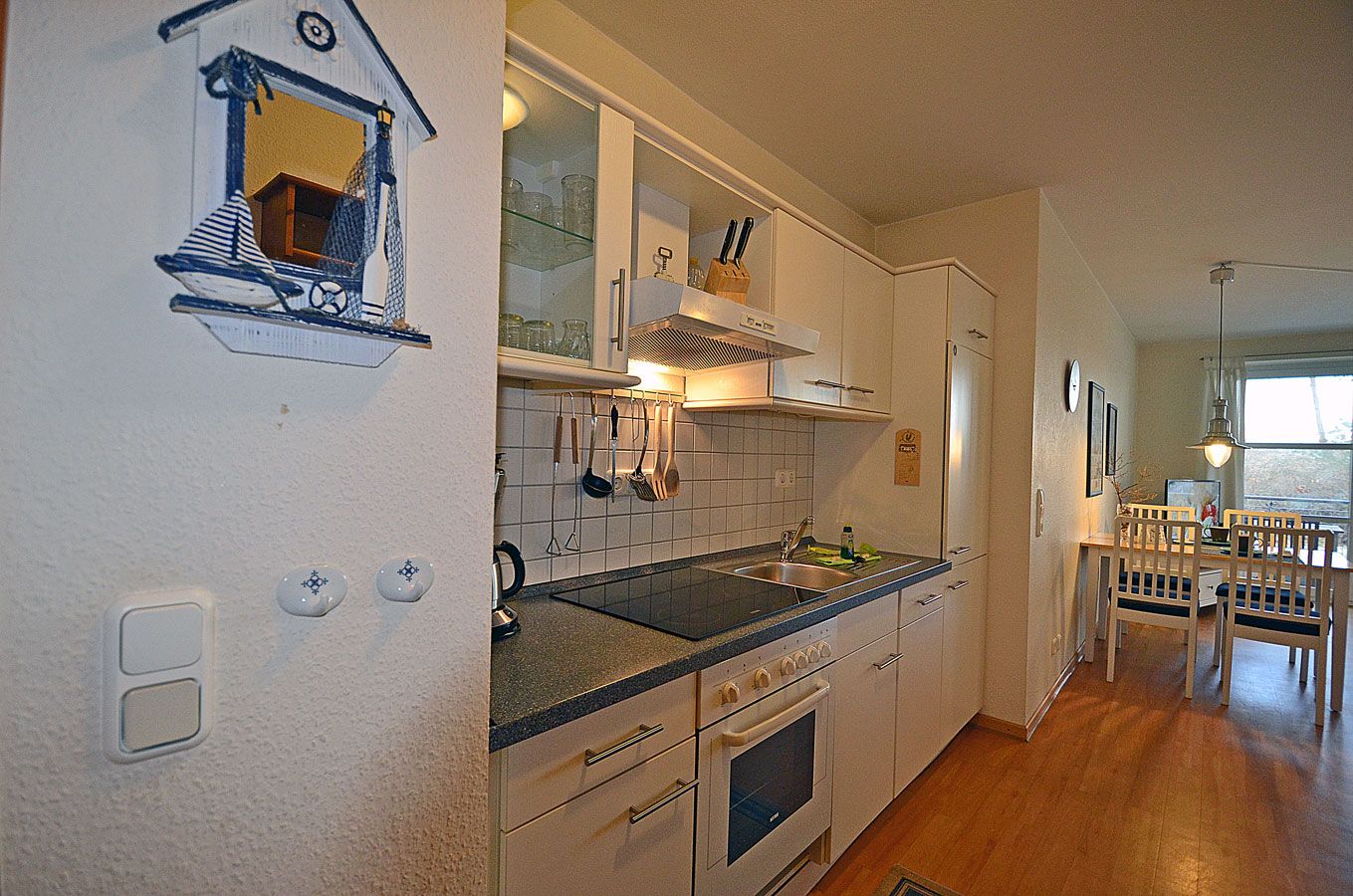 A kitchen with white cabinets, a black countertop, and a window.