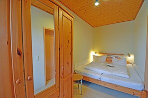 Ein Schlafzimmer mit einem hölzernen Bettgestell, einem Nachttisch und einem Kleiderschrank.