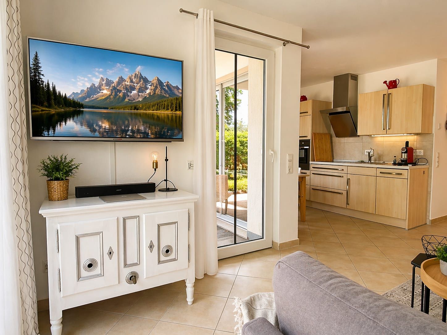 A modern living room with a flat-screen TV, a sofa, and a dining area with a table and chairs.