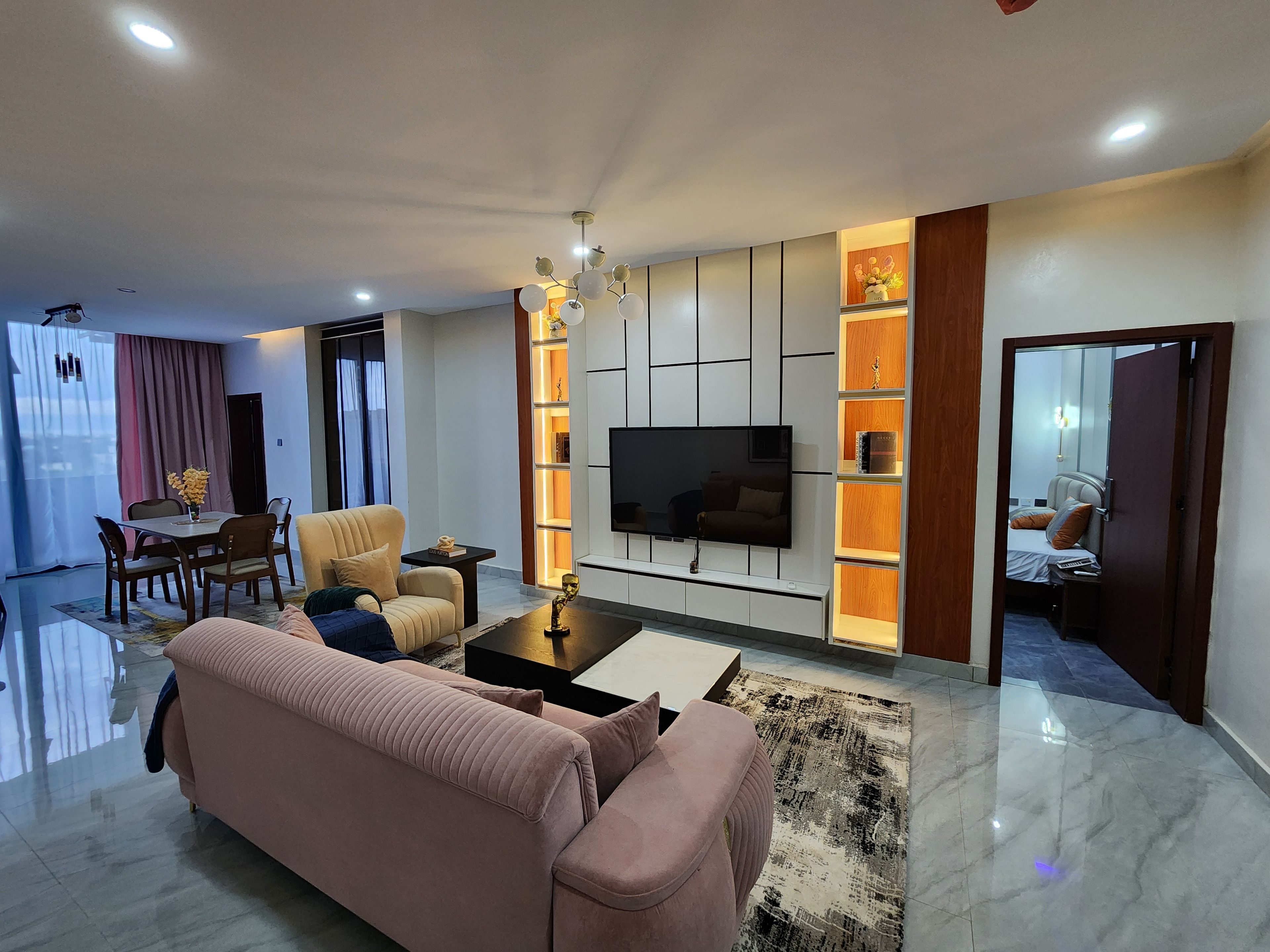 A modern living room with a sofa, a coffee table, and a TV mounted on the wall.