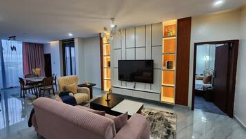 A modern living room with a sofa, a coffee table, and a TV mounted on the wall.