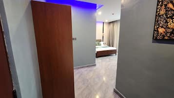 A modern hotel room with a bed, a nightstand, and a painting on the wall.