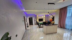 Uma sala de estar moderna com mesa de bilhar, um sofá e um espaço de jantar.