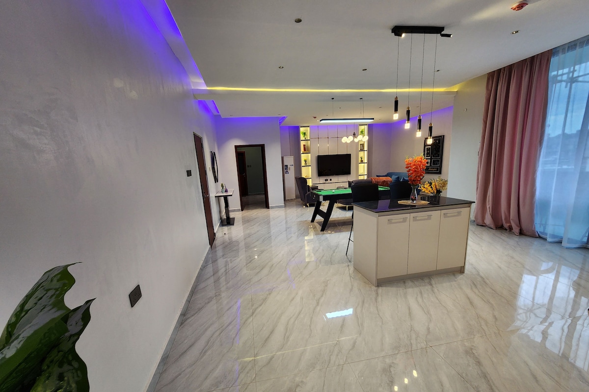 Una sala moderna con mesa de billar, sofá y comedor.