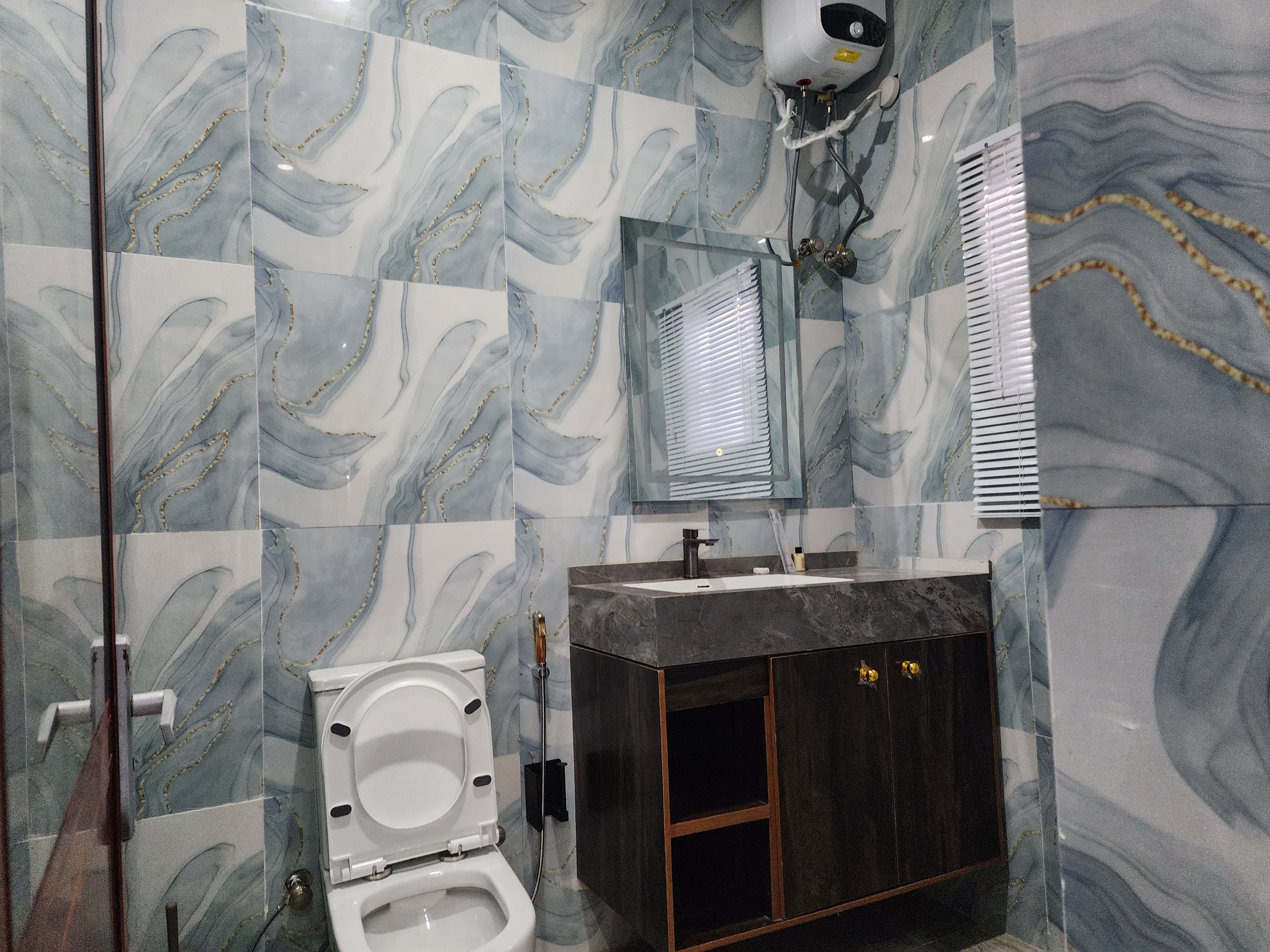 A bathroom with a toilet, sink, and mirror.