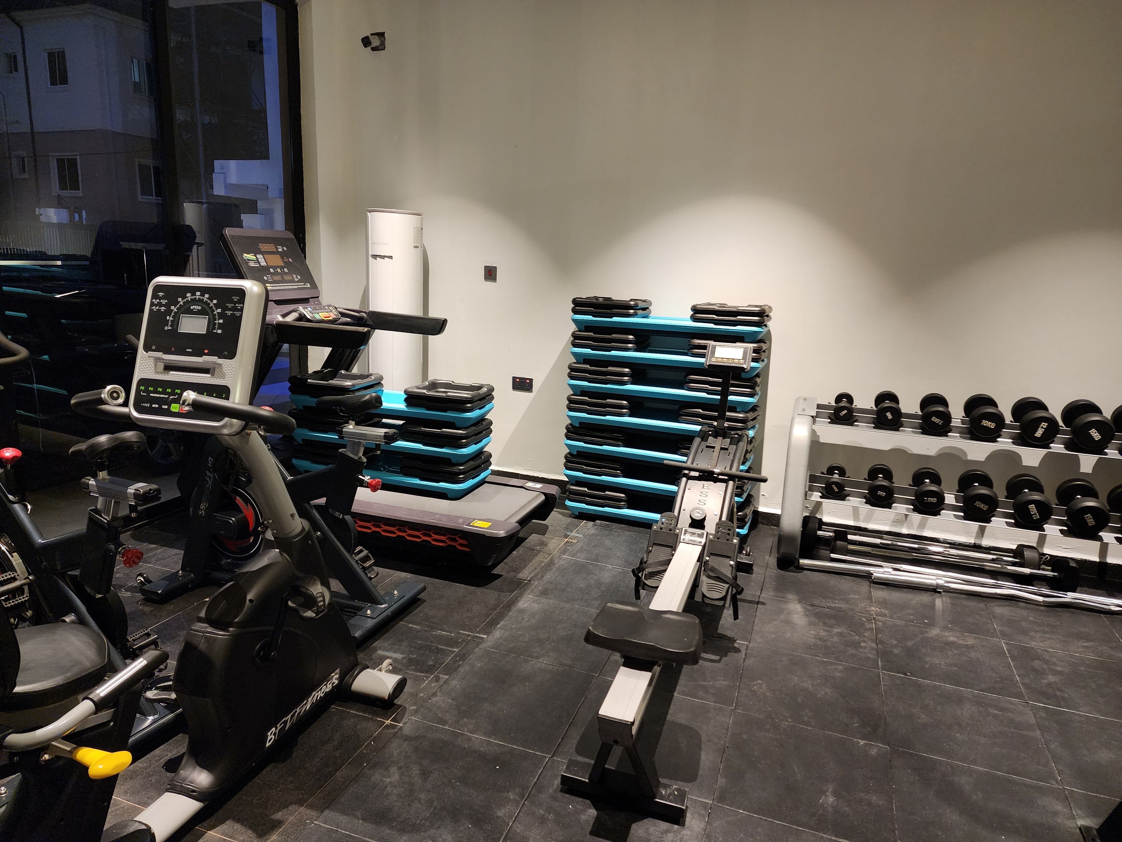Et fitnesscenter med træningsudstyr, vægtapparater og håndvægte.