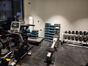 A gym with exercise equipment, weight stacks, and dumbbells. - Sethhotel Apartment & Suite (Asaba)