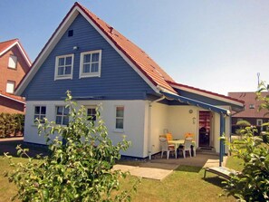 A two-story house with a red roof, a covered porch, and a small garden. - Quiet location with a terrace, about 6 km from the Baltic Sea, about 800 m from the Bodden (Wiek)