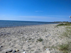 A beach with a clear sky, sandy shore, and a calm sea. - Quiet location with a terrace, about 6 km from the Baltic Sea, about 800 m from the Bodden (Wiek)