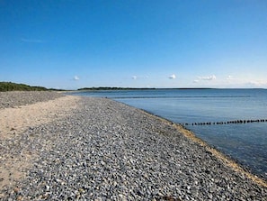 A pebbled beach with calm water and a clear sky. - Quiet location with a terrace, about 6 km from the Baltic Sea, about 800 m from the Bodden (Wiek)