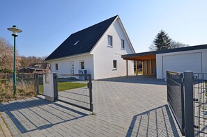 A modern house with a paved driveway, a gated entrance, and a garage. - 800 meters to the beach, 3 bedrooms, sleeps up to 6, Wi-Fi, washing machine (Breege)