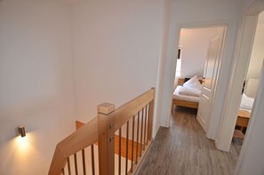 A staircase leading to a bedroom with a bed, a nightstand, and a door. - Only about 750 meters from the beach, fireplace, Wi-Fi, washing machine, dryer, sleeps up to 4 people (Breege)