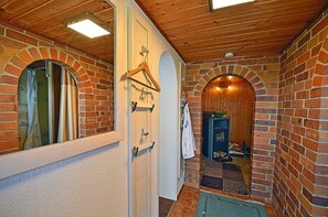 A hallway with brick walls, wooden ceiling, and a fireplace. - Vacation home in a very quiet location with a view of the Bodden; pets allowed; 2 bedrooms (Breege)