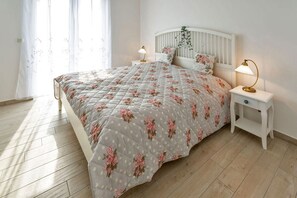 Ein Schlafzimmer mit einem Bett, Nachttischen und einem Fenster mit Vorhängen.