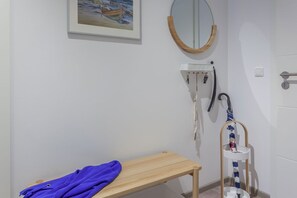 A bathroom with a wooden bench, a sink with a mirror, and a hanging towel rack. - 1,800 m from the beach, 2 bedrooms, sleeps up to 4, Wi-Fi, washing machine, sauna (Breege)