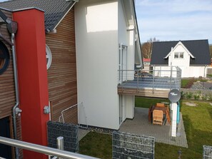 Um imóvel residencial com varanda, antena parabólica e uma pequena área de estar ao ar livre.