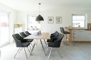 A modern kitchen with a dining area, featuring a wooden table, black chairs, and a pendant light. - High-end furnishings with a fireplace, about 350 meters from the beach, sleeps up to 6, Wi-Fi (Breege)