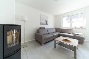 A modern living room with a sofa, a coffee table, a floor lamp, and a television. - High-end furnishings with a fireplace, about 350 meters from the beach, sleeps up to 6, Wi-Fi (Breege)