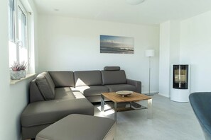A modern living room with a sectional sofa, a coffee table, a floor lamp, and a fireplace. - High-end furnishings with a fireplace, about 350 meters from the beach, sleeps up to 6, Wi-Fi (Breege)
