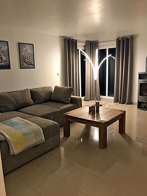 A living room with a sofa, a coffee table, and a fireplace. - Luxurious semi-detached house, about 800 m from the beach, sleeps up to 6, with a sauna and washing machine (Breege)