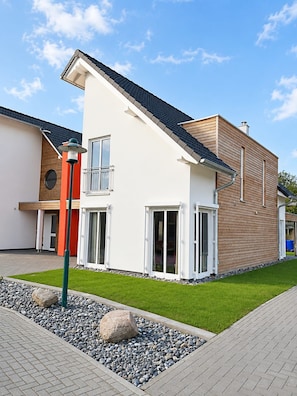 A modern two-story house with a flat roof, large windows, and a well-maintained lawn. - Luxurious semi-detached house, about 800 m from the beach, sleeps up to 6, with a sauna and washing machine (Breege)