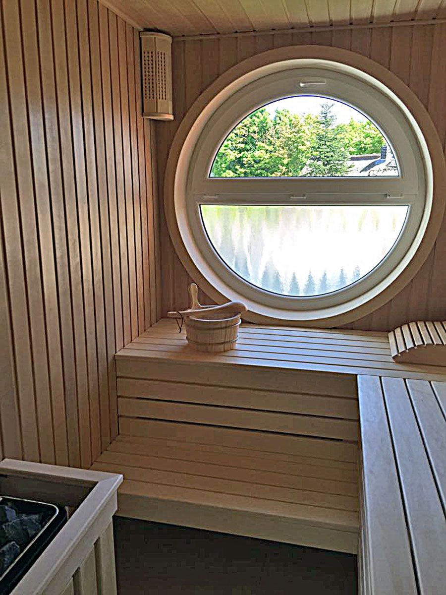 A sauna with a wooden interior, a window, and a bench.