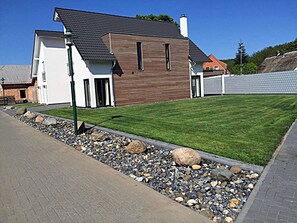 Ein modernes, zweistöckiges Haus mit gepflasterter Auffahrt und gepflegtem Rasen.