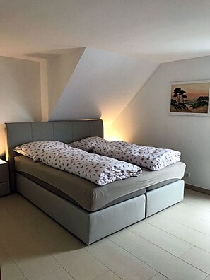 Ein modernes Schlafzimmer mit einem Bett, Nachttischen und einem Bild an der Wand.