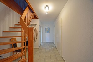 A wooden staircase leading to a landing with a coat rack and a framed map on the wall. - Just 700 meters from the Baltic Sea beach, with a fireplace, Wi-Fi, and a washing machine; sleeps up to 6 people. (Breege)