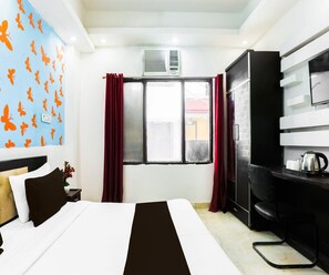 Ein Hotelzimmer mit einem Bett, einem Kleiderschrank, einem Fenster mit Vorhängen und einer Wand mit Schmetterlingsstickern.