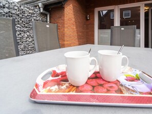A table with two white mugs on a tray with a fruit design. - Holiday Home With 1 Bedroom (Neuharlingersiel)
