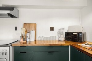 A kitchen with a microwave, toaster, and coffee maker on the counter.
