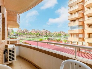 A balcony with a view of a cityscape, featuring a red-tiled floor and a white railing. - Oropesa Apartment With Terrace (Oropesa del Mar)