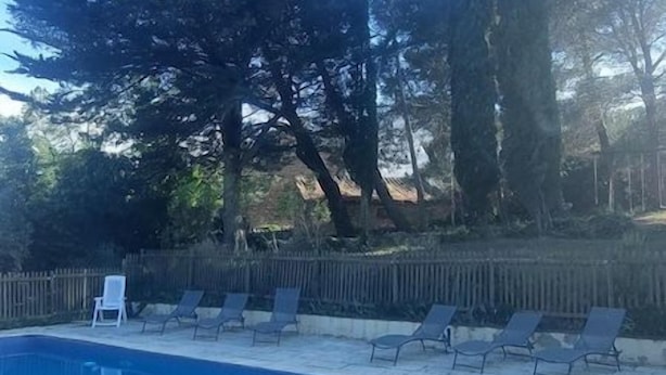 Uima-allas, jossa on aurinkotuoleja ja aita.