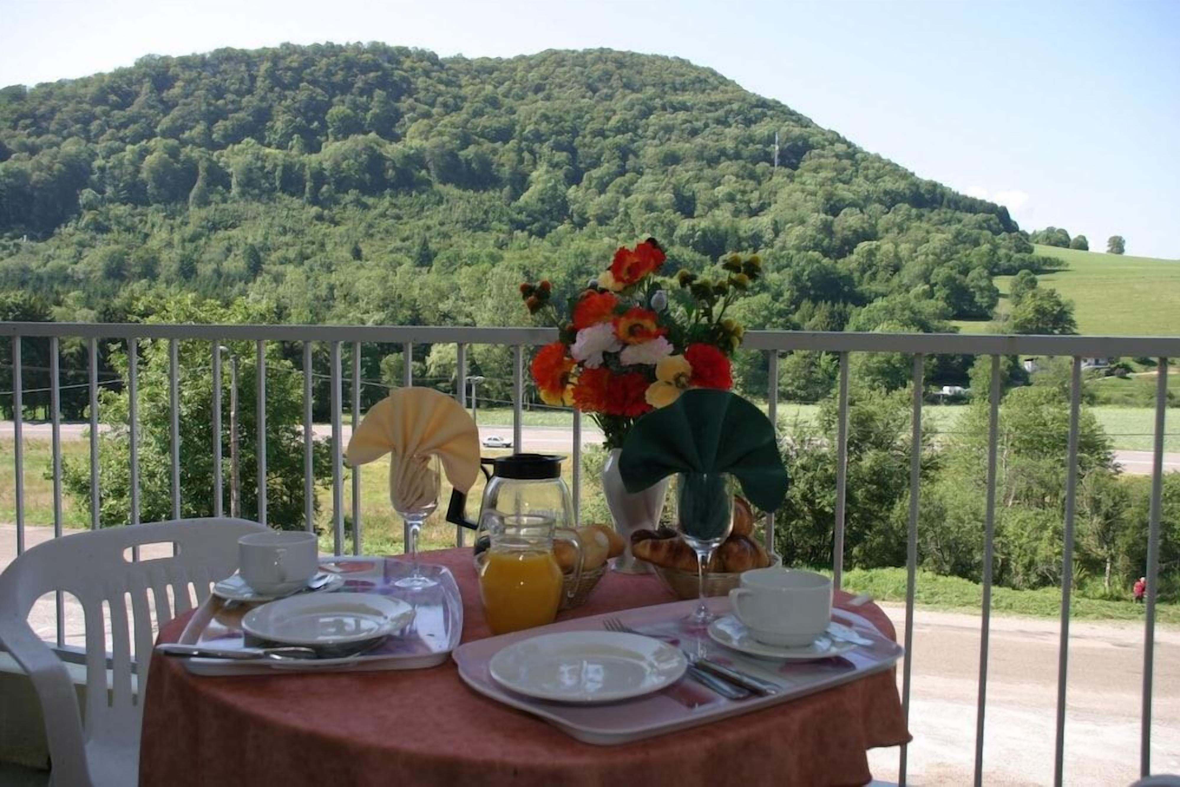 Una mesa lista para el desayuno con una vista a la montaña al fondo.
