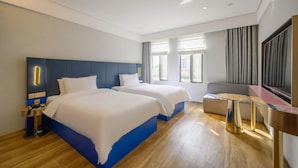 A hotel room with two beds, a desk, a TV, and a window with curtains. - Spring Sunlight (Xiamen)