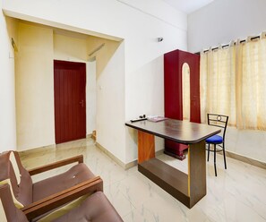 A room with a desk, a chair, a red door, and a window with curtains. - Saver Double Ambience Home (Chennai)