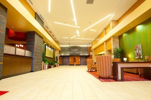 Un vestíbulo de hotel con mostrador de recepción, zona de estar y un letrero que dice 'CHIEF'S EVENT CENTER'.
