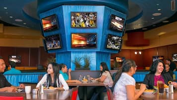 A restaurant with multiple screens displaying sports content, seating arrangements, and a casual dining atmosphere.