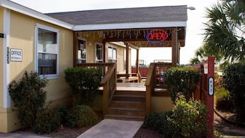 A building with a porch, a sign indicating an office, and a number 632 on the door.